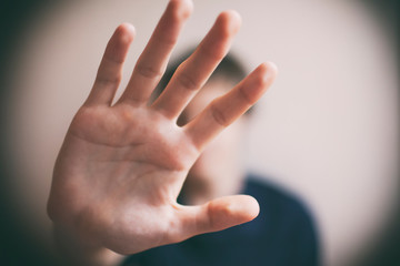 Teen boy protects himself with open palm
