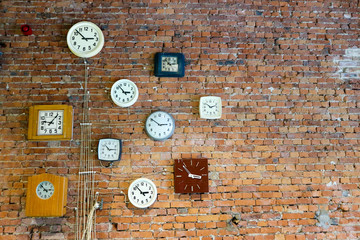 Composition of old vintage clock on the red brick wall