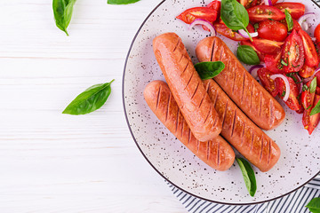 Grilled sausage with tomatoes, basil salad and red onions. BBQ menu. Top view