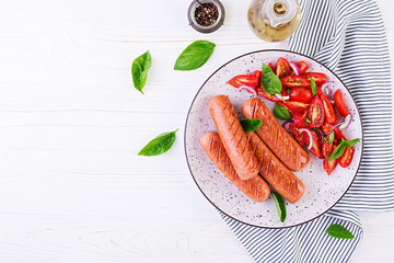 Grilled sausage with tomatoes, basil salad and red onions. BBQ menu. Top view