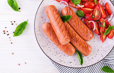 Grilled sausage with tomatoes, basil salad and red onions. BBQ menu. Top view
