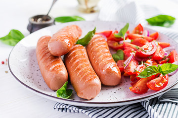 Grilled sausage with tomatoes, basil salad and red onions. BBQ menu.