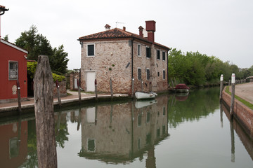 Obraz premium casa sul fiume con barca