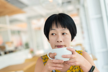 Asian woman hold a cup of coffee