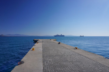 Fototapeta na wymiar Kos, Greece: View of a cruise ship and the coast of Turkey, from the harbor of Kos, an island in the Dodecanese chain in the Aegean Sea.