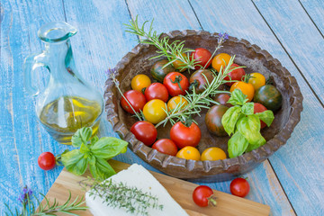 Display of freshly picked heirloom tomatoes with a variety of fresh herbs, Feta Cheese and Olive Oil 