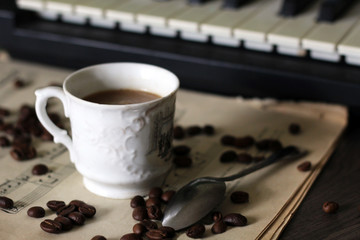 A Cup of hot coffee, musical notes and a piano.