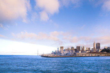 Fototapeta na wymiar City of San Francisco California seen from the Bay with Bay Bridge, docks and buildings of skyline in view.