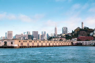 Naklejka premium City of San Francisco California seen from the Bay with boats, docks, wharf and buildings of skyline in view.