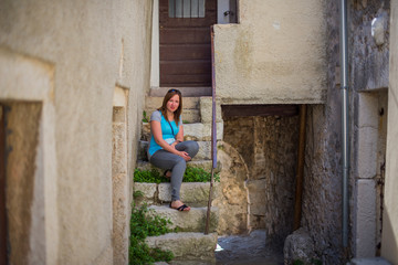 Fototapeta na wymiar Young woman on the stairs of a old Croatian city.