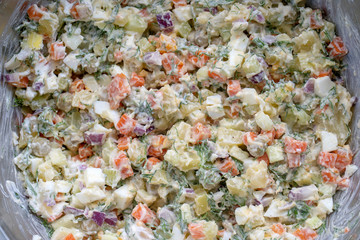 Healthy homemade russian traditional salad olivier ready to eat, close up