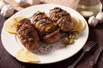 Baked potato with onions and spices on a white dish on the background of a wooden table