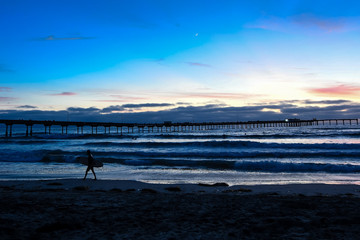 Fototapeta premium Silhouette of a Surfer at Sunset at Ocean Beach in San Diego California, USA