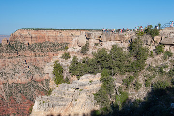 Tourists enjoy view of Grand Canyon from Mather Point on sunny summer afternoon in Grand Canyon National Park, Arizona.