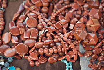 Necklace of colorful stones on the table. Many different jewelry and beads made of natural precious minerals. Stones jewelry is on sale at the fair.