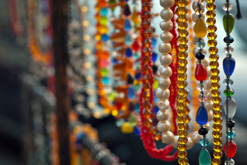 Necklace of colorful stones on the table. Many different jewelry and beads made of natural precious minerals. Amber jewelry is sold at the fair.