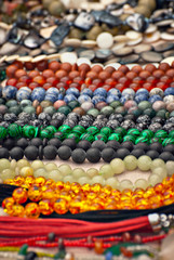 Necklace of colorful stones on the table. Many different jewelry and beads made of natural precious minerals. Jewelry is sold at the fair.