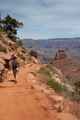Fototapeta na wymiar Young woman hiking on South Kaibab Trail in Grand Canyon National Park South Rim, Arizona on sunny summer afternoon.