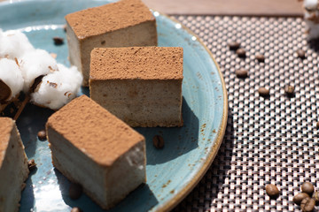 Raw vegan cake tiramisu on the plate, with coffee beans