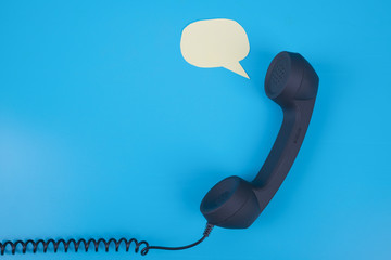 Handset phone with speech bubble on a blue background. With place for text. Copy space
