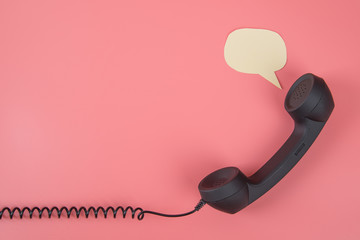 Handset phone with speech bubble on a pink background. With place for text. Copy space
