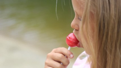 little girl eating a lollipop