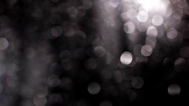  Bokeh Of Raindrops On Window features a bokeh shot of raindrops sliding on a window pane at night. It looks like this clip was taken from inside a vehicle on a rainy evening.