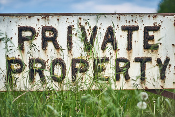 Vintage private property sign in the spring meadow. Close up