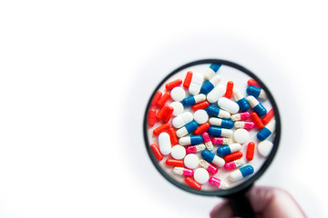 Multicolored capsules isolated on white background, copyspace for text, selective focus, top view. Pain meds, health, pills for the treatment of the concept of drug abuse