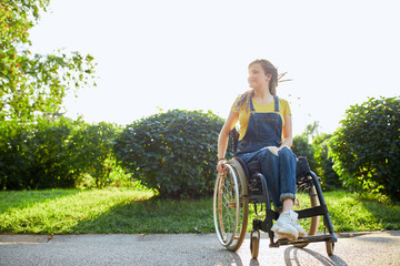 Fototapeta na wymiar gorgeous positive girl in wheelchair rejoicing at new day, full length photo. positive feeling and emotion. copy space. love of life, cheerfullness