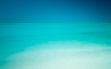 panorama of turquoise tropical water stretching out to a blue sky
