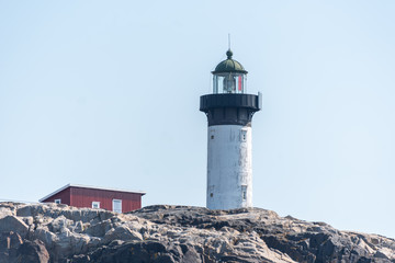 Fototapeta na wymiar Ursholmen, Sweden - July 26, 2019: View of the lighthouse of the island Ursholmen on the Swedish west coast.