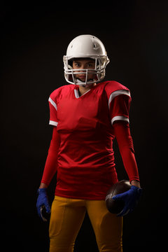 Image of football player woman in helmet looking at camera on empty black background