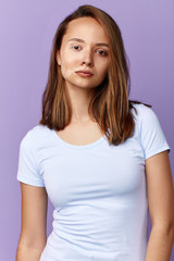 hipster unhappy serious upset girl has many pigment spots on face. close up portrait. isolated blue background, studio shot