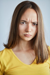 frowning serious girl isn't satisfied with hernface, close up portrait. anger concept. isolated white background