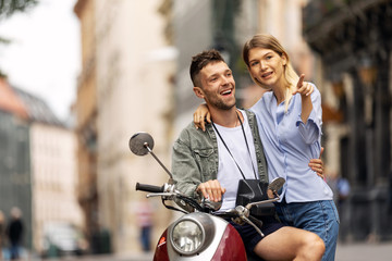 Fototapeta na wymiar Happy couple of tourist travelers around city with motorbike scooter