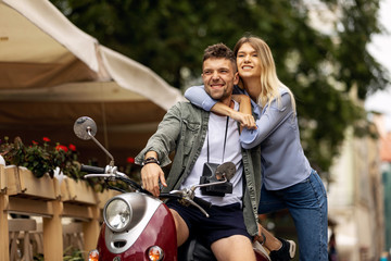 Naklejka na ściany i meble Happy couple of tourist travelers around city with motorbike scooter