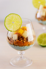 Garnola with yogurt, melon, peach and spirulina in a glass.