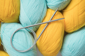 Mint and yellow acrylic yarn with knitting needles. Beautiful mint and yellow yarn for knitting baby clothes. For yarn, children's clothing store, flyer design, banner, for site