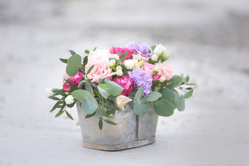 Flower arrangement in a box with spray pink roses, succulent, eustoma, white hypericum, eucaliptus.