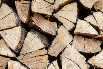 Close-up of dried wood for burning bonfire. Background of dry chopped wood folded for the fireplace. A pile of firewood for heating a house.
