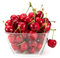 Ripe red cherries in bowl on white. Background isolated