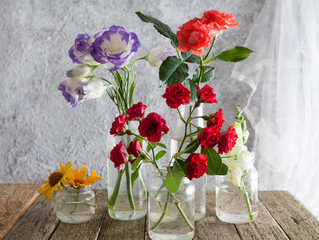 flowers in vases-jars on a wooden table