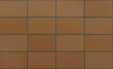 Texture of a wall build with big brown tiles