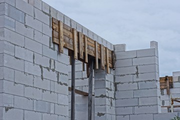 part of an unfinished house of white brick against the sky