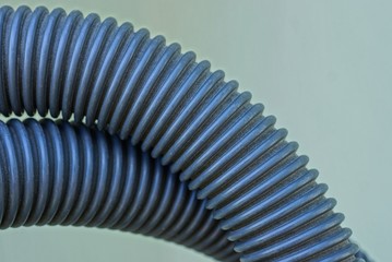 long gray plastic hose against a green background