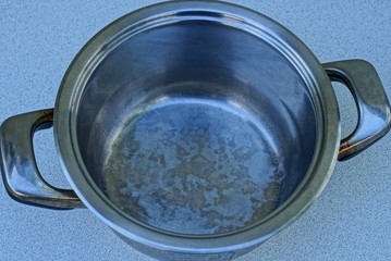  gray open metal pan stands on a white table