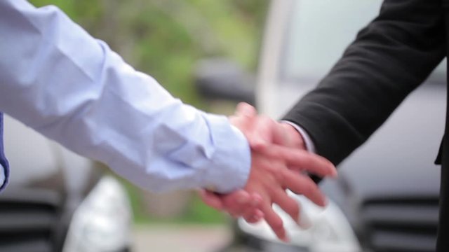 The Man Purchases A New Car stock video is an excellent bit of footage that exhibits a sales agent handing in the keys to a new car owner. They then happily shake hands to seal the deal.