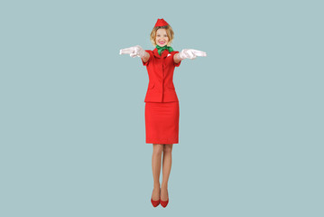 Beautiful stewardess wearing in red uniform on gray background.