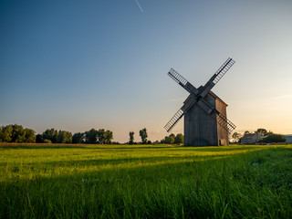 Fototapeta na wymiar Old windmill on the green field.